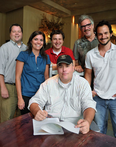 Veteran BMI musician and songwriter Pete Sallis recently inked a deal with premier Christian music publisher Brentwood Benson Publishing Group. Pictured at BMI in Nashville are (back row) BMIs Bradley Collins, Brentwood Benson Publishing Groups Stacey Wilbur, John Andrade, Brentwood Bensons Dale Mathews, and Eric Hurt, with Pete Sallis, seated. (Photo: Drew Maynard) 