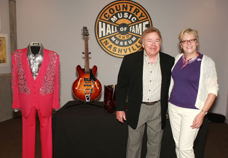 Country Music Hall of Fame member Roy Clark donated several items to the Country Music Hall on Fame and Museum on Saturday (7/18).  The artifacts, which will be on display beginning August 1 in the Museums permanent exhibit, include a magenta three-piece Manuel suit with an embroidered silver lame` Manuel shirt, patent leather Tony Lama boots, and a Heritage H-535 Roy Clark Signature model electric guitar.  PicturedClark and Vice President of Museum Services Carolyn Tate  Photo by Richard Suter