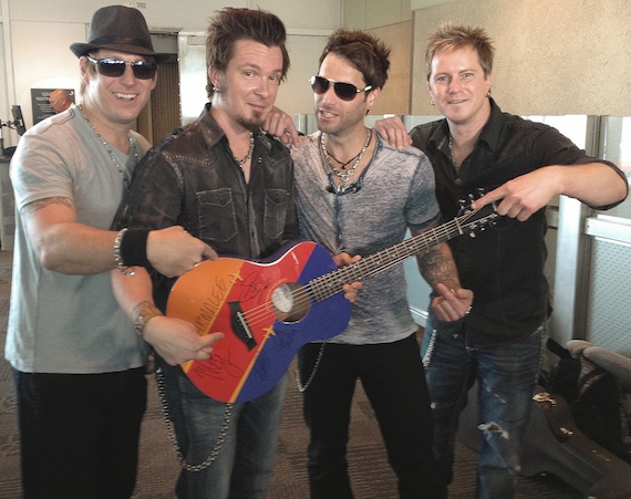 Pictured (L to R): Scott Thomas, Josh McSwain, Matt Thomas and Barry Knox post-performance with the official autographed Southwest Airlines Travelin Taylor Tour custom GS Mini guitar