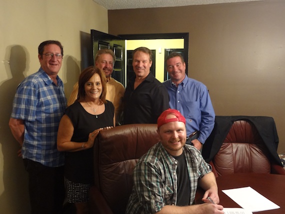 Pictured (L-R) are: Sam Ramage, Chief Creative Officer, Blue Guitar; Lori Maxwell, CFO, Blue Guitar; Danny Pool, owner of the publishing company; Mike Kraski, General Manager, Blue Guitar; Daniel Wood, President, Blue Guitar and Timmer (seated).