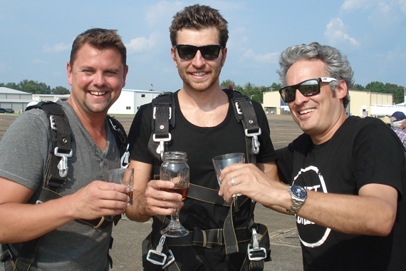 Atlantic/WMN recording artist Brett Eldredge recently made good on his promise to skydive if his single Dont Ya made it to the top of the charts. Pictured (L-R): Storme Warren (SiriusXM), Eldredge, and Byron Kennedy (KNCI) 