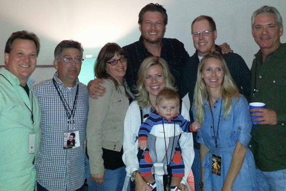 Warner Bros./WMN entertainer Blake Shelton played this weeks No. 3 single Mine Would Be You to a sold out show in Milwaukee after taking part in a radio hang. Pictured (L-R) BACK: Mike Ferris (WMAD), Fletcher Keys (WWQM), Charli McKenzie (WNCY), Shelton, Dave Ogden (WWQM), Kerry Wolf (WMIL). FRONT: Katie Bright (WMN) with her baby-bjorned son Leo, and Kristen Williams (WMN).