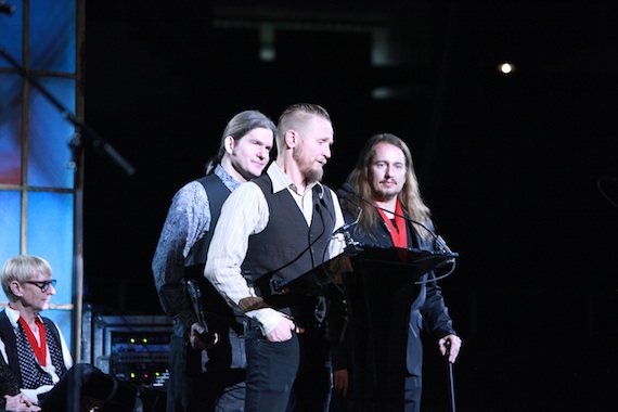 Sons of the late Roy Orbison, (left) Wesley Orbison (back), Alex Orbison (at mic) and Roy Kelton Orbison Jr. (far right) speaking on behalf of their father for his induction into the Musicians Hall of Fame in the Iconic Riff category for his legendary hit song Oh, Pretty Woman on the stage of Nashvilles Historic Municipal Auditorium on January 28th 