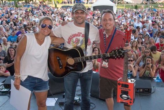 BMI singer/songwriter Rhett Akins performs on the BMI Tailgate stage at CMA Fest. Akins has written a slew of country hits, including Hey Girl, Parking Lot Party and Young & Crazy. BMIs Jody Williams and Leslie Roberts present Rhett Akins with a custom Bohemian Guitar in celebration of the multiple Million Air awards he received that night, celebrating more than 25 titles with millions of spins.